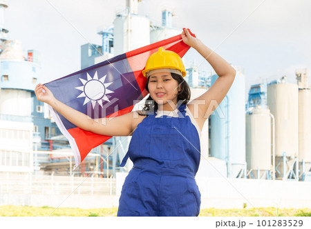 Portrait of positive girl in construction overalls with the Taiwan flag on the background of modern factory 101283529