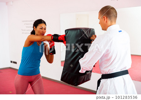 Man is training with woman and punching gloves in box gym Man is training with woman and punching gloves in box gym 101283536