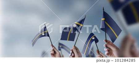 A group of people holding small flags of the Nauru in their hands 101284285