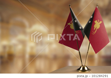Small flags of the Papua New Guinea on an abstract blurry background 101284291