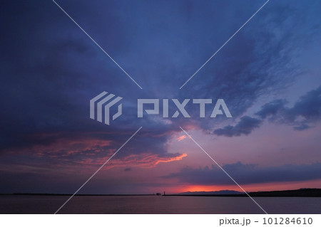 空一面を覆う不気味な暗雲が夕焼けした港の風景・春・超広角・空主体・230402pm 101284610