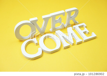Over Come alphabet letters on yellow background 101286902