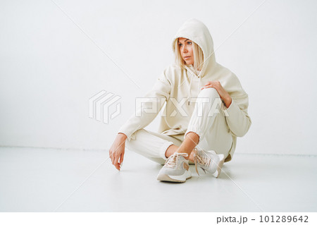 Young blonde woman in sportswear on background of white wall 101289642