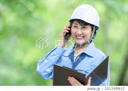 電話をする作業服の女性 電話をする作業服の女性 101289912