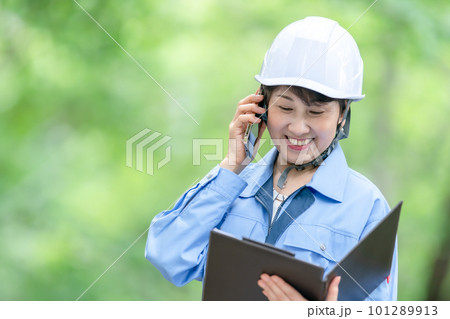電話をする作業服の女性 電話をする作業服の女性 101289913