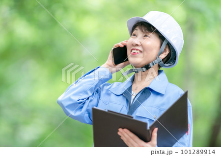電話をする作業服の女性 電話をする作業服の女性 101289914