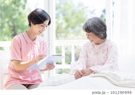 訪問介護 ベットに座るシニア女性から聞き取りをする介護士 訪問介護 ベットに座るシニア女性から聞き取りをする介護士 101290999