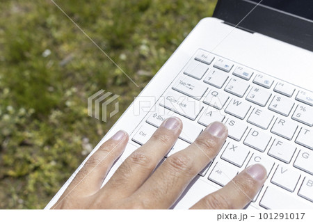 ノートパソコンと男性の手と草原。外でテレワークするイメージ ノートパソコンと男性の手と草原。外でテレワークするイメージ 101291017