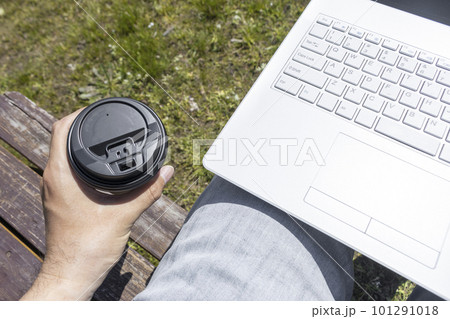 ノートパソコンと男性の手と草原。外でテレワークするイメージ 101291018
