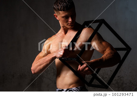 Athlete bodybuilder trains in the studio in the rain. 101293471