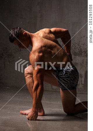 Athlete bodybuilder trains in the studio in the rain. Athlete bodybuilder trains in the studio in the rain. 101293508