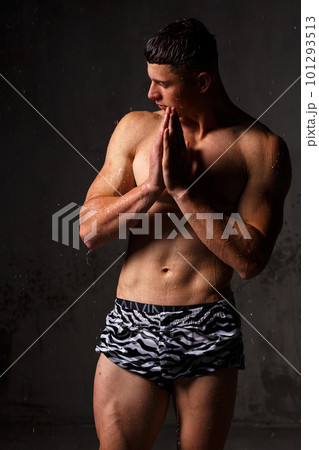 Athlete bodybuilder trains in the studio in the rain. 101293513