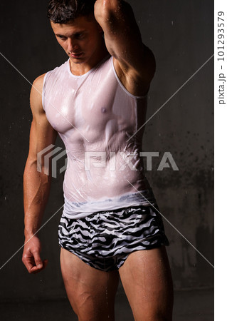 Athlete bodybuilder trains in the studio in the rain. 101293579