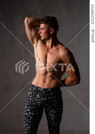 A guy in a great sports uniform in the studio on a gray background. A guy in a great sports uniform in the studio on a gray background. 101294059