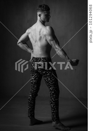 A guy in a great sports uniform in the studio on a gray background. 101294068