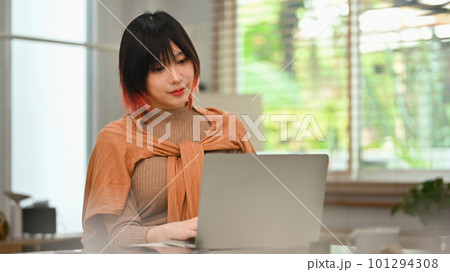 Portrait of young stylish woman using laptop at home office. Freelance, creative occupation, e-learning concept 101294308