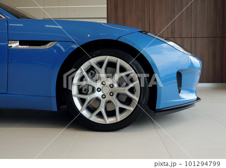 The front part of a sports car on low profile tires in the showroom of a car dealer The front part of a sports car on low profile tires in the showroom of a car dealer 101294799