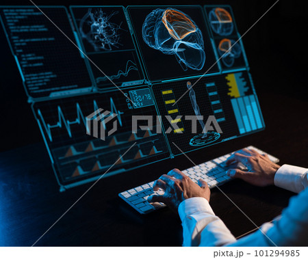 Caucasian man sits in the dark in front of a virtual menu. Close-up of male hands on the keyboard. 101294985