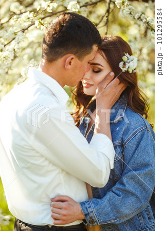 Beautiful loving couple in blooming gardens. Wedding concept. Great sunset light. Lovely newlyweds. 101295584