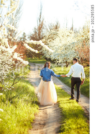 Beautiful loving couple in blooming gardens. Wedding concept. Great sunset light. Lovely newlyweds. Beautiful loving couple in blooming gardens. Wedding concept. Great sunset light. Lovely newlyweds. 101295585