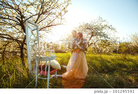 Beautiful loving couple in blooming gardens. Wedding concept. Great sunset light. Lovely newlyweds. 101295591