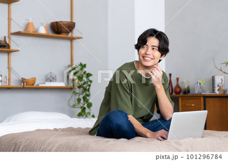 寝室でパソコンを使う若い男性 101296784