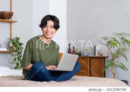 寝室でパソコンを使う若い男性 101296790