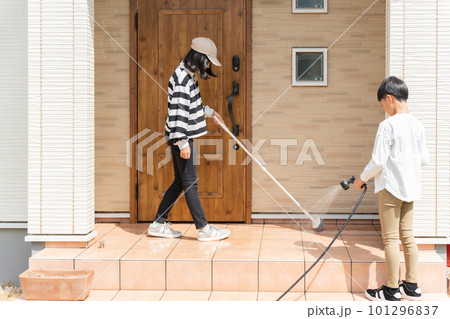 玄関の土間をブラシで掃除をする小学生の男の子と女の子 101296837