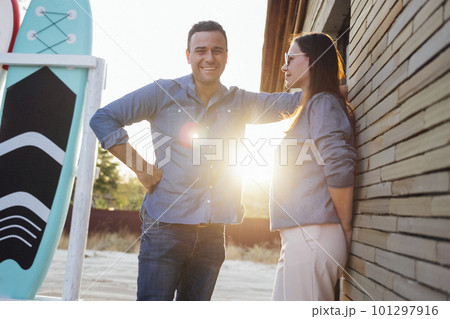 Young man hugging beautiful woman on background of surfboards Young man hugging beautiful woman on background of surfboards 101297916