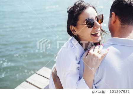 Young couple in love in light casual clothes is sitting on wooden bridge 101297922