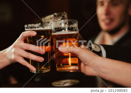 glasses with light beer in hands of happy clinking friends glasses with light beer in hands of happy clinking friends 101298085