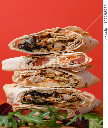 Three types of cut shawarma placed on top of each other, red background and fast food. 101298959