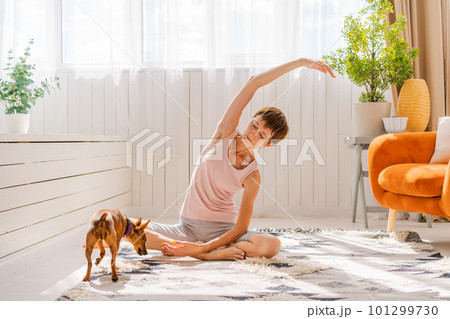 Concept healthy lifestyle. Yoga and fitness. Cute woman with small dog Concept healthy lifestyle. Yoga and fitness. Cute woman with small dog 101299730
