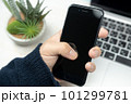 スマートフォンを持つ男性の手と観葉植物 101299781