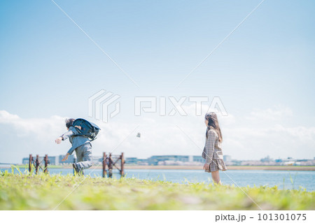 晴天の昼間、川沿いで石投げをして楽しそうに遊ぶ男の子と女の子の兄弟 晴天の昼間、川沿いで石投げをして楽しそうに遊ぶ男の子と女の子の兄弟 101301075