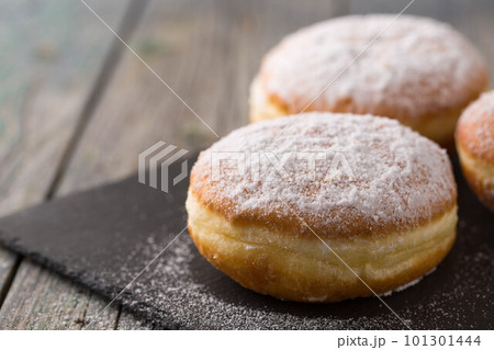 Ruddy delicious donuts berliners on a stone board Ruddy delicious donuts berliners on a stone board 101301444