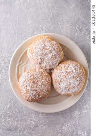 Ruddy delicious donuts berliners with filling sprinkled with powdered sugar on a white plate, top view 101301448