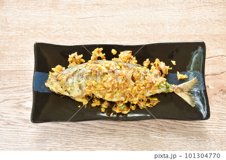 deep fried mackerel fish with turmeric dressing chili and garlic on plate in white background deep fried mackerel fish with turmeric dressing chili and garlic on plate in white background 101304770