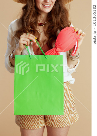 smiling woman in blouse and shorts against beige smiling woman in blouse and shorts against beige 101305382