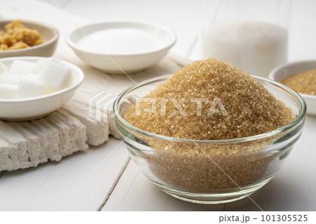 Yellow sanding cane sugar in glass bowl,Various granulated sugar on white table Yellow sanding cane sugar in glass bowl,Various granulated sugar on white table 101305525