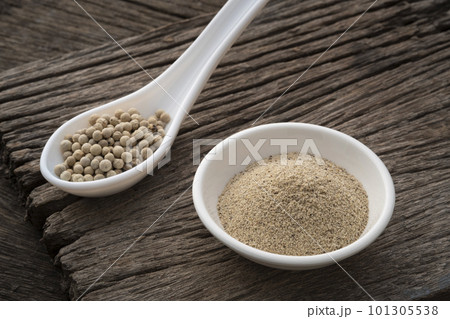 ground white pepper in white bowl on wooden table ground white pepper in white bowl on wooden table 101305538