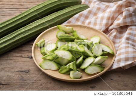 Sliced Fresh Angled luffa (Ribbed Gourd) fruits on wooden bowl 101305541