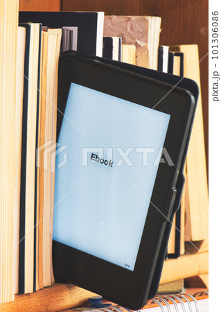Detail of an e book reader among classic books 101306086