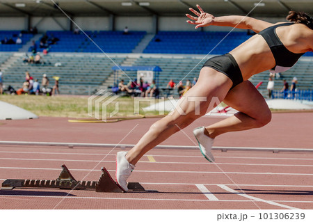 female sprinter start from starting blocks running on stadium track, summer athletics championship female sprinter start from starting blocks running on stadium track, summer athletics championship 101306239