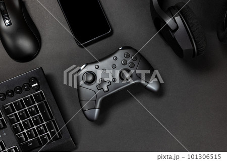 Top view of game controller with gadgets and mobile phone on black gamer desk 101306515