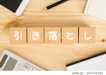 引き落としと書かれたブロック、電卓、スマホ、ノート、カレンダー 101310181