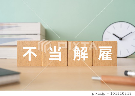 不当解雇と書かれたブロックが置かれたデスク 101310215