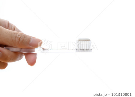 歯磨き粉をつけた透明の歯ブラシを持つ男性の手　白バック　歯磨き　健康習慣　トリミングアップ 101310801