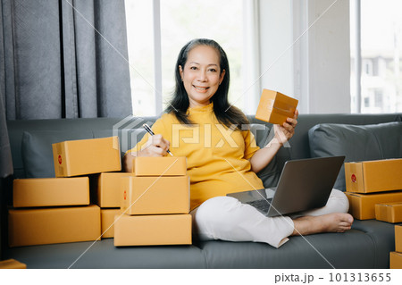 Senior business owner woman prepare parcel box and standing check online orders for deliver to customer on tablet, laptop Shopping Online concept.. 101313655