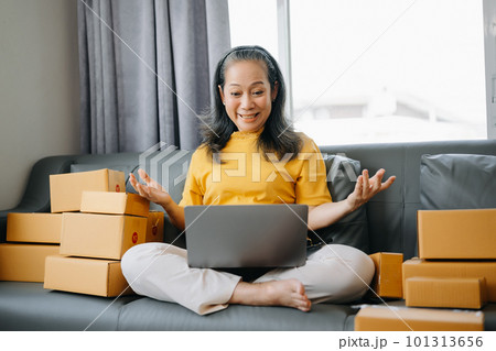 Senior business owner woman prepare parcel box and standing check online orders for deliver to customer on tablet, laptop Shopping Online concept.. 101313656